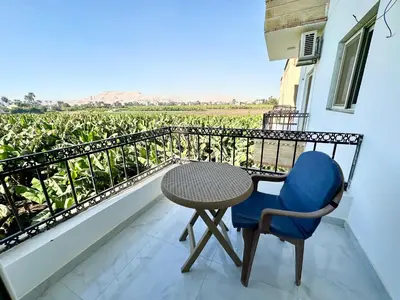a balcony with a table and a chair and a view at Sheherazade Guesthouse in Luxor