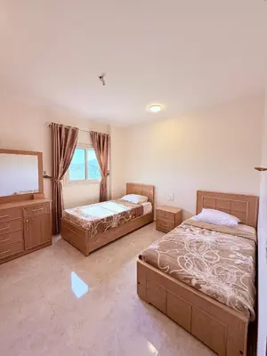 a bedroom with two beds and a mirror at Sheherazade Guesthouse in Luxor