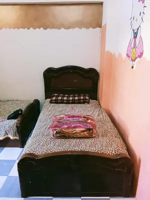 a bedroom with a bed with a brown head board at الشواربي السياحي سوق الحارث in Aswan