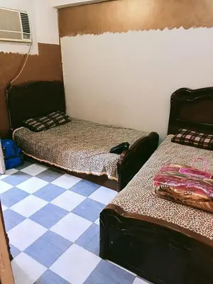 a room with two beds and a checkered floor at الشواربي السياحي سوق الحارث in Aswan