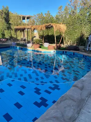 a swimming pool with a blue tile floor and a pavilion at Hurghada Jungle Clube House Compound 1 bedroom Хургада компаунд студия в Джангл с 1 спальней in Hurghada