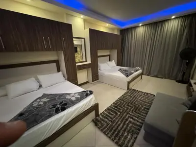 a hotel room with two beds and a couch at Cecilia resort hurghadaمنتجع سيسيليا in Hurghada