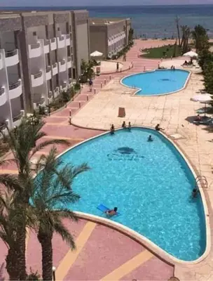 an overhead view of a large swimming pool next to the beach at Cecilia resort hurghadaمنتجع سيسيليا in Hurghada