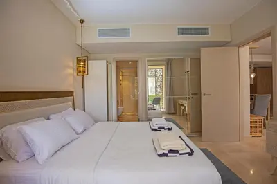 a bedroom with a large white bed with towels on it at Ollystays Mangroovy 1 BR Beach and Pool Free access in Hurghada