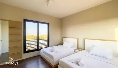 two beds in a room with a large window at Ollystays 4BR Townhouse Shared Pool El Gouna in Hurghada