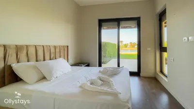 a white bed with two towels on top of it at Ollystays 4BR Townhouse Shared Pool El Gouna in Hurghada