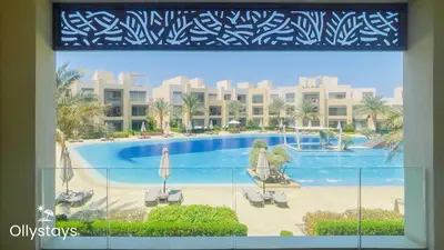 a view of a swimming pool from a window at Ollystays Mangroovy 3BR Beach and Pool Free access in Hurghada