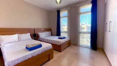 a bedroom with two beds and a window at Ollystays Mangroovy Seaview 2BR Beach and Pool Free access in Hurghada