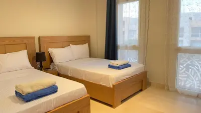a bedroom with two beds and a window at Ollystays Mangroovy Seaview 2BR Beach and Pool Free access in Hurghada