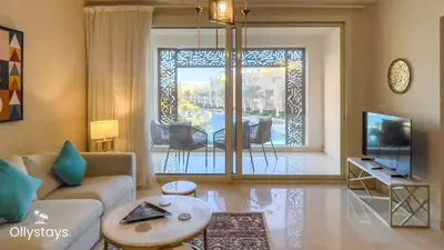 a living room with a couch and a tv at Ollystays Mangroovy Seaview 2BR Beach and Pool Free access in Hurghada