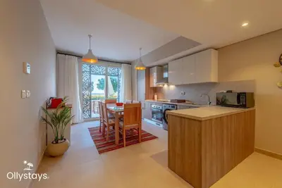 a kitchen with a table and a dining room at Ollystays Mangroovy Seaview 2BR Beach and Pool Free access in Hurghada
