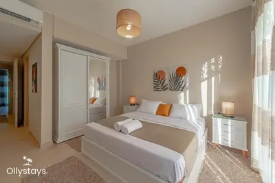 a bedroom with a large bed in a room at Ollystays Mangroovy Seaview 2BR Beach and Pool Free access in Hurghada