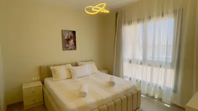 a bedroom with a bed with a large window at Ollystays Shedwan 1BR Pool & lagoon access in Hurghada
