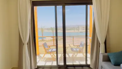 a living room with a sliding glass door with a patio at Ollystays Shedwan 1BR Pool & lagoon access in Hurghada