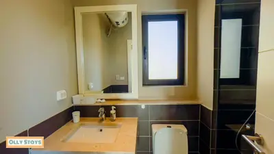 a bathroom with a sink and a mirror and a toilet at Tawila 4BR Villa Private Pool in Hurghada