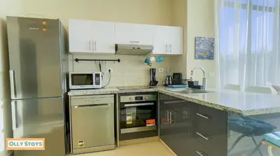 a kitchen with a stainless steel refrigerator and a microwave at Tawila 4BR Villa Private Pool in Hurghada