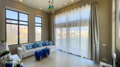 a living room with a couch and large windows at Ollystays Tawila 2BR Apt Shared pool El Gouna in Hurghada
