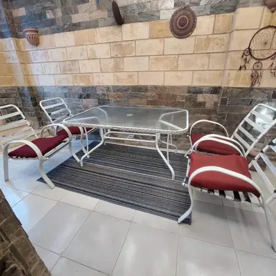 a table and chairs in a room with a wall at Marina 2 bedroom flat in Hurghada