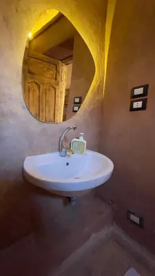 a white sink in a bathroom with a mirror at Massel Belosso in Aswan