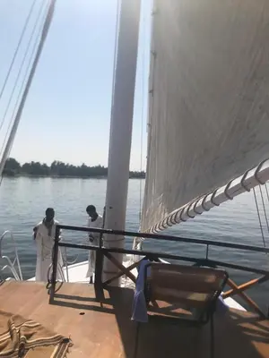 two men standing on a boat in the water at Nubian Sandal in Aswan