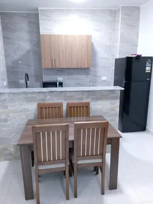 a kitchen with a wooden table and a black refrigerator at Dody apartments rent services in Luxor