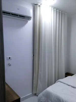 a bedroom with a bed and a white curtain at Dody apartments rent services in Luxor