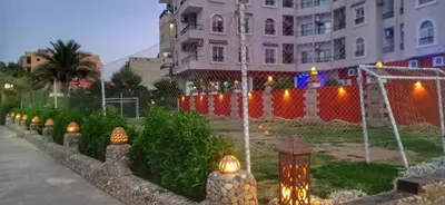 a row of lights in a garden in front of a building at منتجع اباظة السياحى in Hurghada