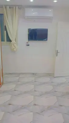 a room with a white wall and a tile floor at اهلا بيكم في بيتنا in Jazīrat al ‘Awwāmīyah