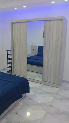 a bedroom with a mirror and a bed in it at اهلا بيكم في بيتنا in Jazīrat al ‘Awwāmīyah