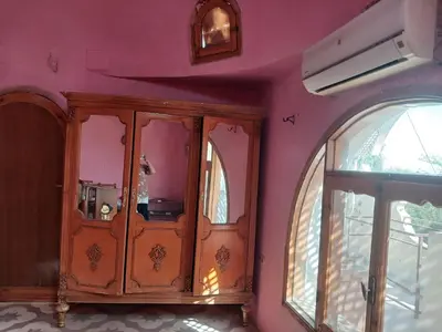 a room with a wooden cabinet and a window at Habu view in Al Karnak