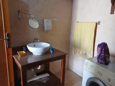 a bathroom with a sink and a washing machine at Habu view in Al Karnak
