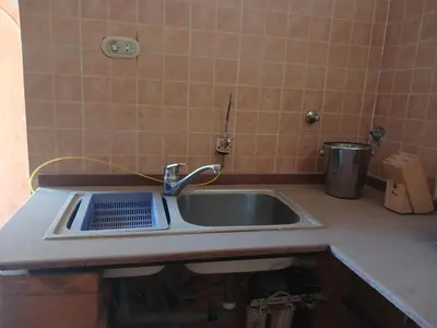 a kitchen counter with a sink and a bucket at Habu view in Al Karnak