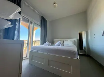 a bedroom with a bed and a large window at waterside apartments in Hurghada
