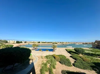 a view of a pool with palm trees and water at waterside apartments in Hurghada
