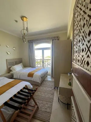 a hotel room with two beds and a window at Your Red Sea Hideaway Apartment in Coraya Bay
