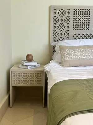 a bedroom with a bed and a side table with books at Your Red Sea Hideaway Apartment in Coraya Bay