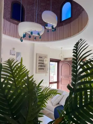 a living room with a couch and two lights at Your Red Sea Hideaway Apartment in Coraya Bay