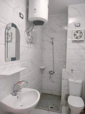 a white bathroom with a sink and a toilet at Tyba view in Hurghada
