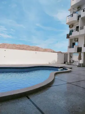 a swimming pool in front of a building at Tyba view in Hurghada