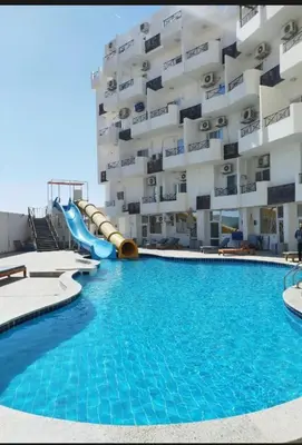 a swimming pool with a slide in front of a building at Tyba view in Hurghada