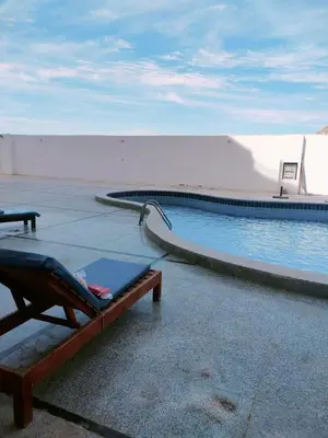 a swimming pool with a lounge chair next to it at Tyba view in Hurghada