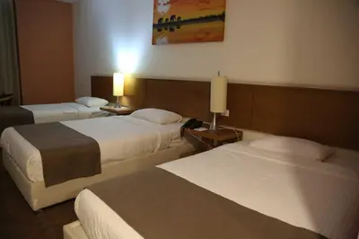 a hotel room with two beds and two lamps at فندق الإيمان El Eman Hotel in Maḩaţţat Idfū