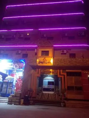 a building with purple lights on top of it at فندق الإيمان El Eman Hotel in Maḩaţţat Idfū