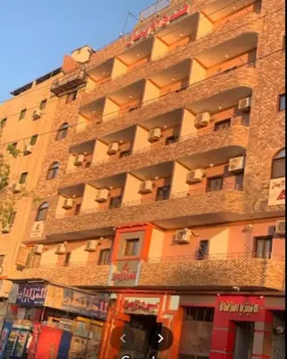 a large brick building with many windows on it at فندق الإيمان El Eman Hotel in Maḩaţţat Idfū