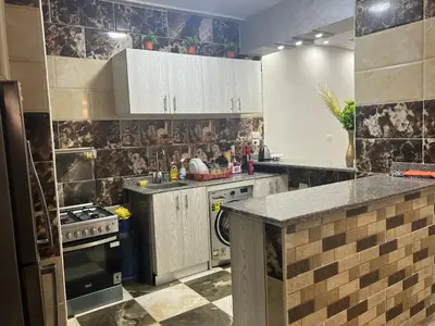 a kitchen with white cabinets and a stove at Dream apartment2 in Hurghada