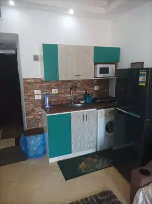 a small kitchen with a sink and a refrigerator at Cecilia resort منتجع سيسيليا in Hurghada