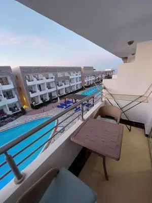 a balcony with a table and a swimming pool at Cecilia resort منتجع سيسيليا in Hurghada