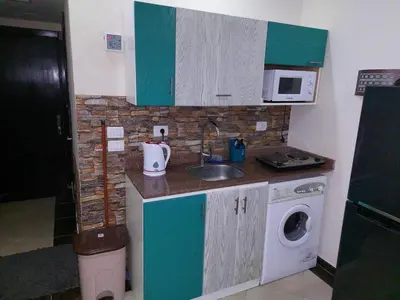 a small kitchen with a sink and a washing machine at Cecilia resort منتجع سيسيليا in Hurghada