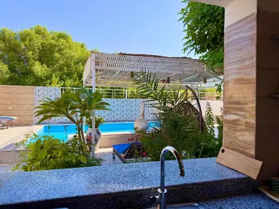 a kitchen sink with a view of a swimming pool at Sylvie guest house in Luxor