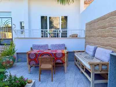 a patio with a table and chairs and a couch at Sylvie guest house in Luxor